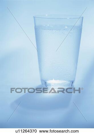 Glass of water, blue background View Large Photo Image Stock Image - Glass of water, blue background. Fotosearch