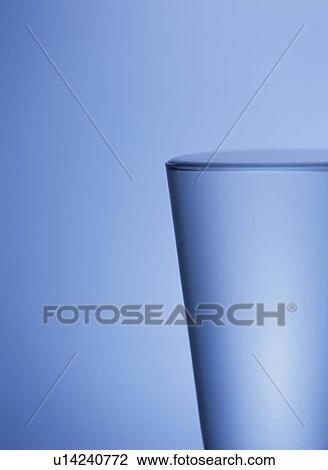 Stock Image - Glass of water, blue background. Fotosearch