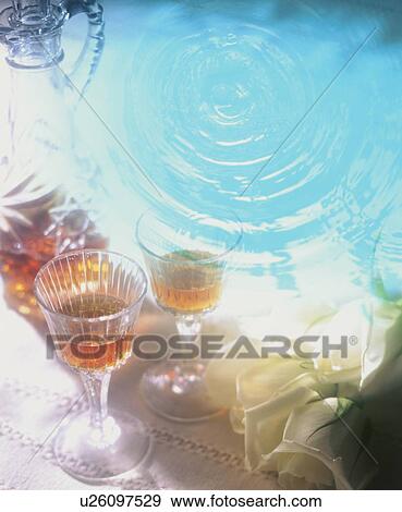 Stock Photo - Glasses of alcohol and rippling water. Fotosearch