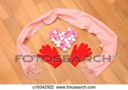 Stock Image - Gloves, scarf and pom poms on floor. Fotosearch