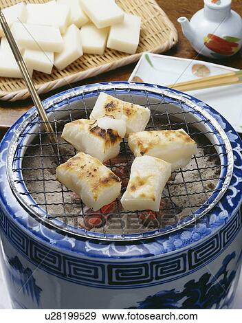 Stock Photo - Grilled mochi over charcoal fire. Fotosearch