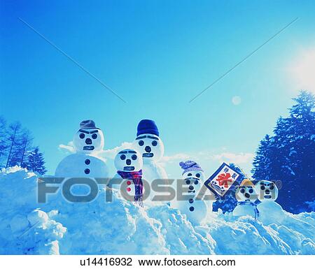 Stock Image - Group of snowmen with a small flag. Fotosearch