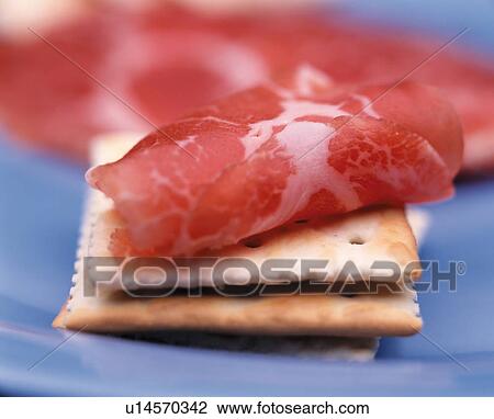 Stock Image - Ham slice on crackers. Fotosearch