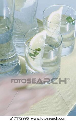Stock Photography - Hand reaching for fresh glass of water. Fotosearch