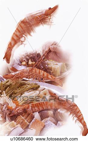 Stock Image - Hand selecting prawn with chopsticks. Fotosearch