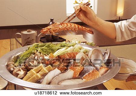 Hand serving seafood from dish with chopsticks View Large Photo Image Stock Image - Hand serving seafood from dish with chopsticks. Fotosearch