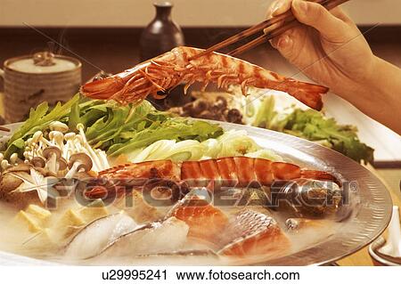 Hand serving seafood from dish with chopsticks View Large Photo Image Stock Image - Hand serving seafood from dish with chopsticks. Fotosearch
