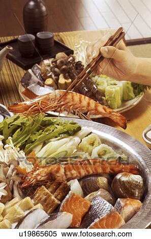 Hand serving seafood from dish with chopsticks View Large Photo Image Stock Photography - Hand serving seafood from dish with chopsticks. Fotosearch
