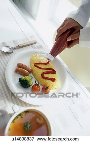 Hands pouring tomato sauce on omelet View Large Photo Image Stock Photo - Hands pouring tomato sauce on omelet. Fotosearch