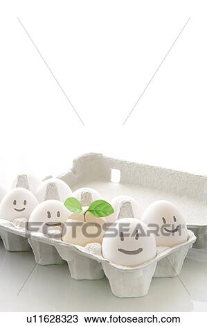 Stock Image - Happy eggs in a carton with a green sprout. Fotosearch