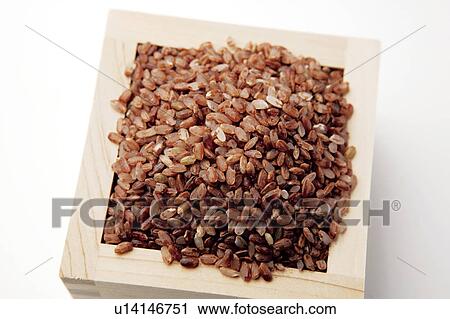Stock Image - Heap of brown rice in wooden box, white background. Fotosearch