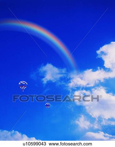 Stock Image - Hot air balloons underneath a rainbow. Fotosearch