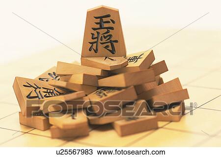 Stock Image - Japanese chess pieces on board, close up. Fotosearch