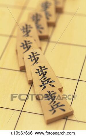 Stock Photograph - Japanese chess pieces on board, close up. Fotosearch