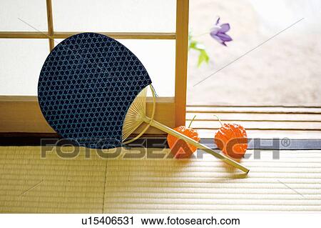 Stock Image - Japanese fan and winter cherry pods on Tatami mat. Fotosearch