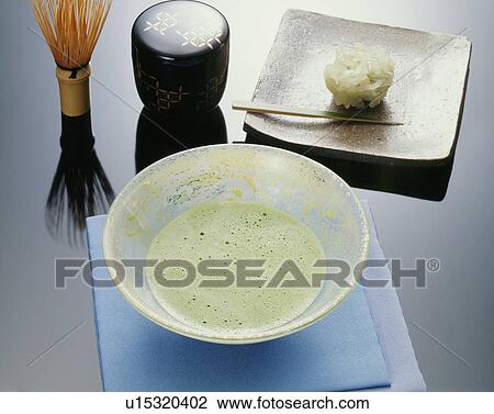 Stock Image - Japanese tea set and plate of shi, black background. Fotosearch