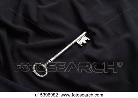 Stock Image - Key on black silk. Fotosearch