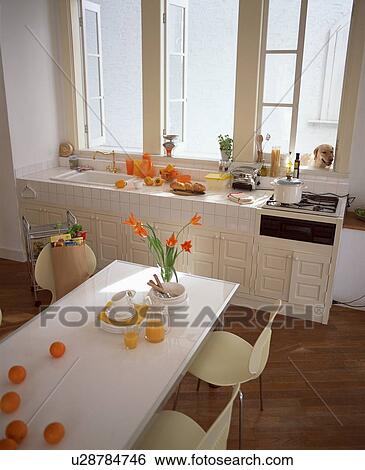 Stock Photograph - Kitchen with oranges, orange juice and orange flowers. Fotosearch