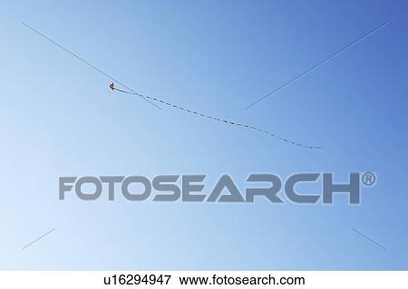 Stock Photo - Kite in blue sky, blue background, copy space. Fotosearch