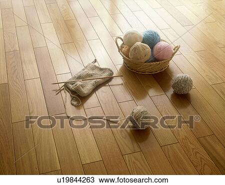 Stock Image - Knitting needles and yarn balls on floor. Fotosearch