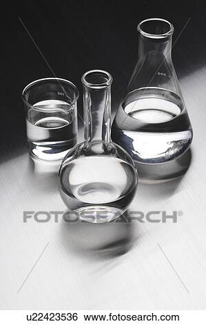 Stock Photograph - Laboratory equipments with liquids, colored background. Fotosearch