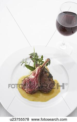 Stock Photo - Lamb chops with mustard sauce and a glass of red wine. Fotosearch