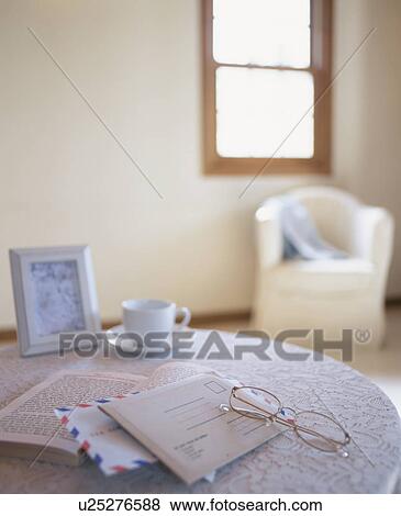 Stock Photo - Letters and glasses on table in living room. Fotosearch