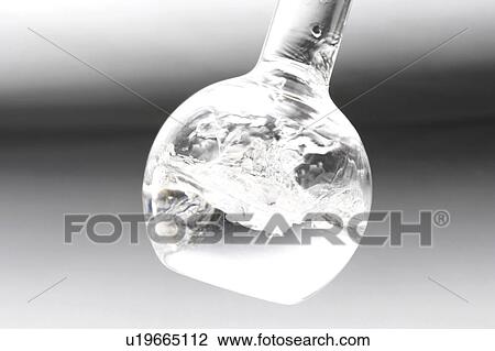 Stock Image - Liquid in flask, colored background. Fotosearch