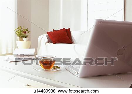 Living room with laptop computer on coffee table View Large Photo Image Stock Photo - Living room with laptop computer on coffee table. Fotosearch