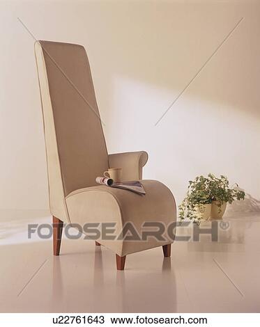 Stock Image - Magazine and cup on modern chair. Fotosearch