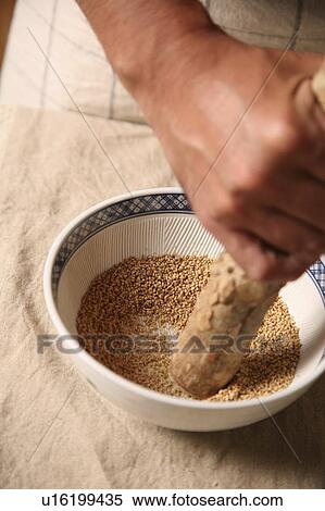 Stock Photography - Man grinding sesame seeds. Fotosearch