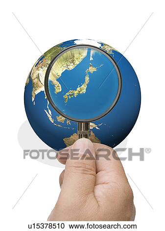 Stock Image - Man looking into globe though magnifying glass. Fotosearch