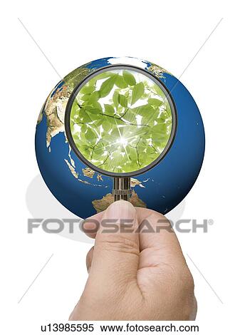 Stock Photography - Man looking into globe though magnifying glass. Fotosearch