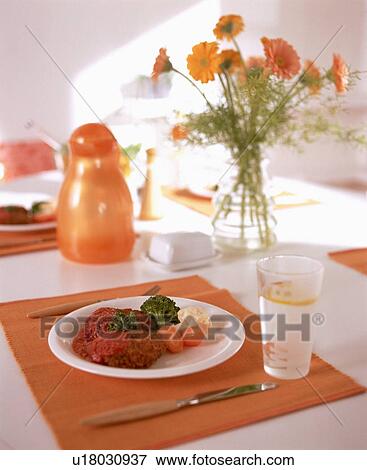 Stock Photo - Meal on table with water glass and flowers. Fotosearch