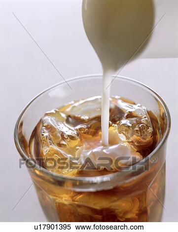 Stock Photography - Milk being poured into ice tea. Fotosearch