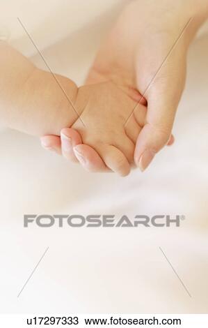Stock Image - Mother and baby holding hands. Fotosearch