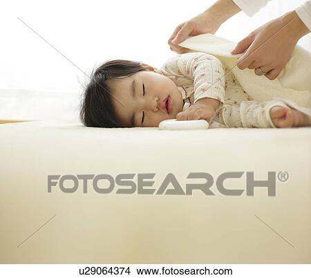 Mother covering sleeping baby with blanket View Large Photo Image Picture - Mother covering sleeping baby with blanket. Fotosearch