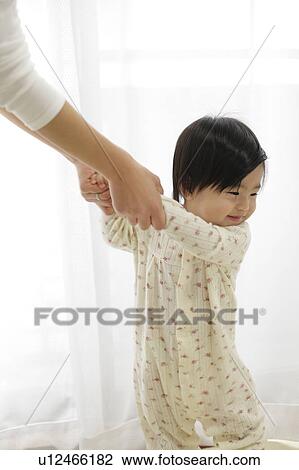 Mother holding baby girl's arms while she stands up View Large Photo Image Stock Image - Mother holding baby girl's arms while she stands up. Fotosearch