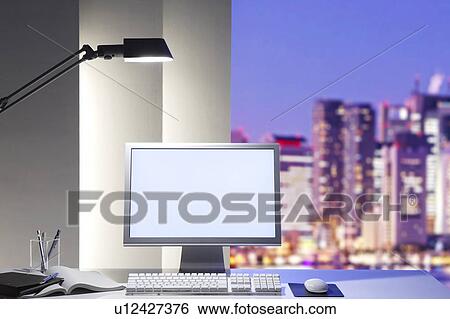 Stock Photograph - Office desk at night. Fotosearch