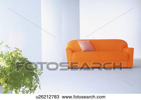 Stock Image - Orange sofa and pot plant in modern room. Fotosearch