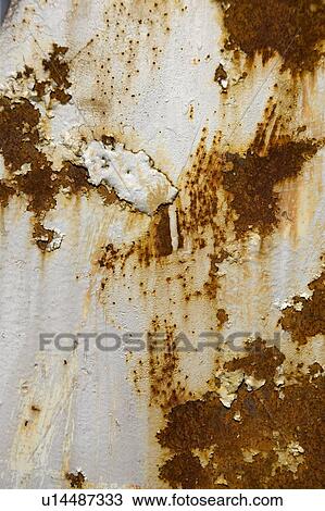 Stock Image - Paint peeling on rusty old wall. Fotosearch