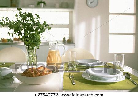 Stock Image - Pastries and plates on dining table. Fotosearch