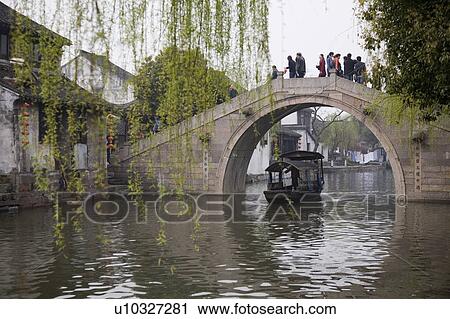 Stock Image - People walking on stone bridge, China. Fotosearch