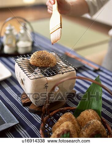 Person glazing rice ball cooking on charcoal brazier View Large Photo Image Stock Photo - Person glazing rice ball cooking on charcoal brazier. Fotosearch
