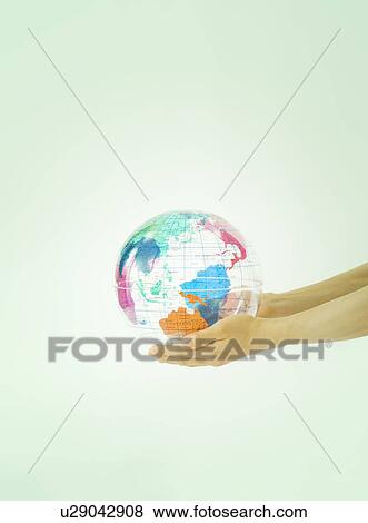 Stock Photo - Person holding transparent globe. Fotosearch
