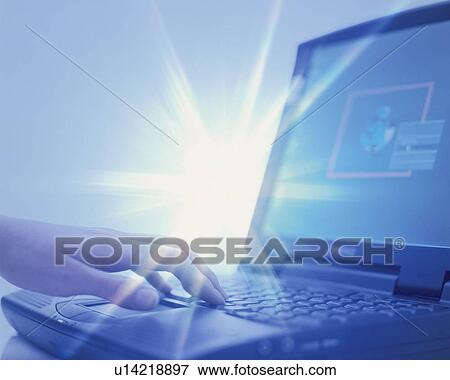 Stock Photo - Person using computer with sunbeams behind - digital composite. Fotosearch