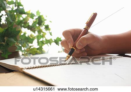 Stock Image - Person writing in notebook. Fotosearch