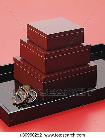 Stock Image - Pile of Japanese wooden boxes, red background. Fotosearch
