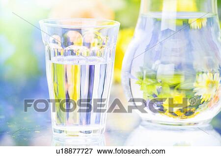 Stock Photo - Pitcher of water next to glass. Fotosearch