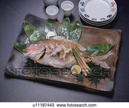 Stock Image - Plate of grilled sea bream, black background. Fotosearch